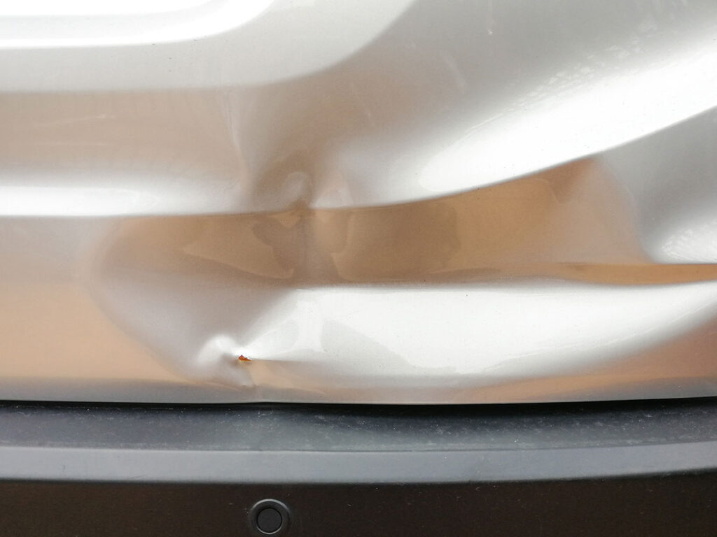 dent in silver car fender