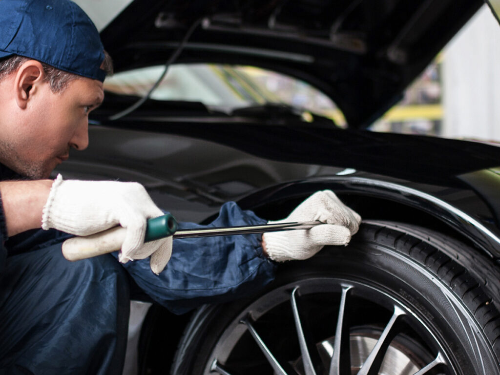 Image of a technician removing a dent from a car