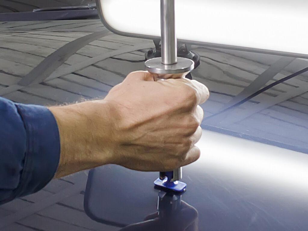 A person removing a dent from a car