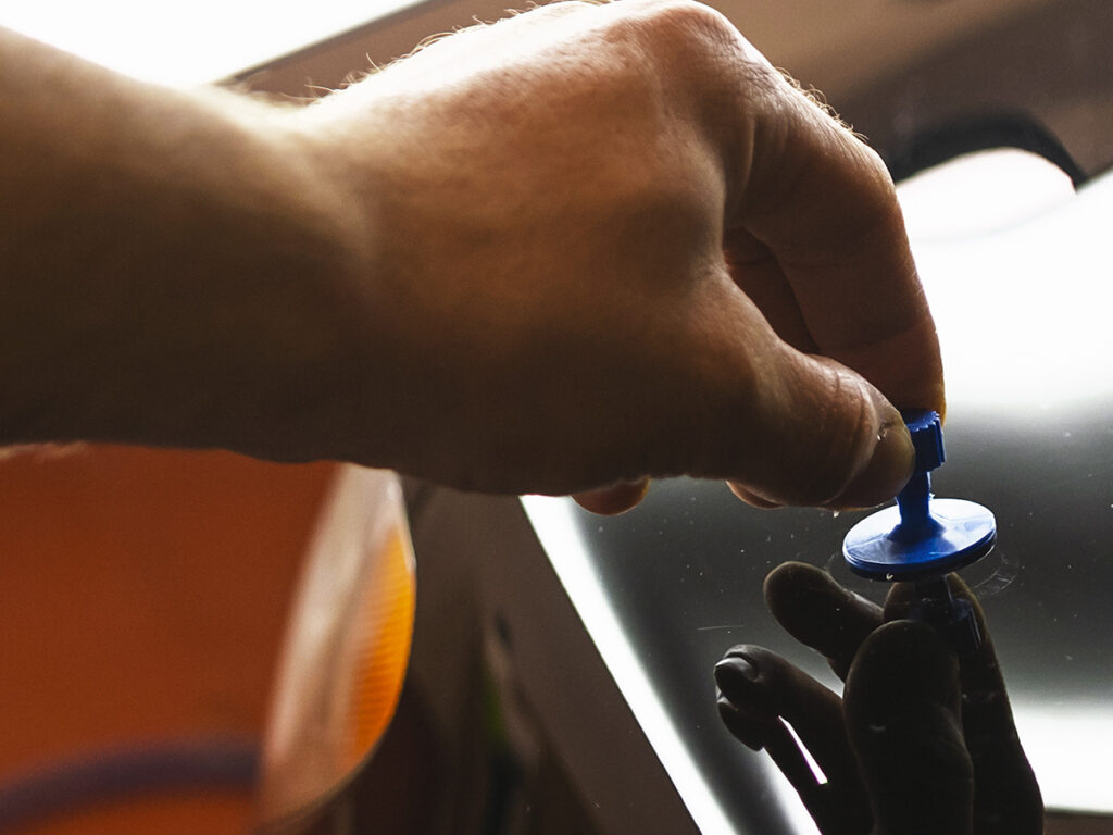 Image of person removing a dent from a car